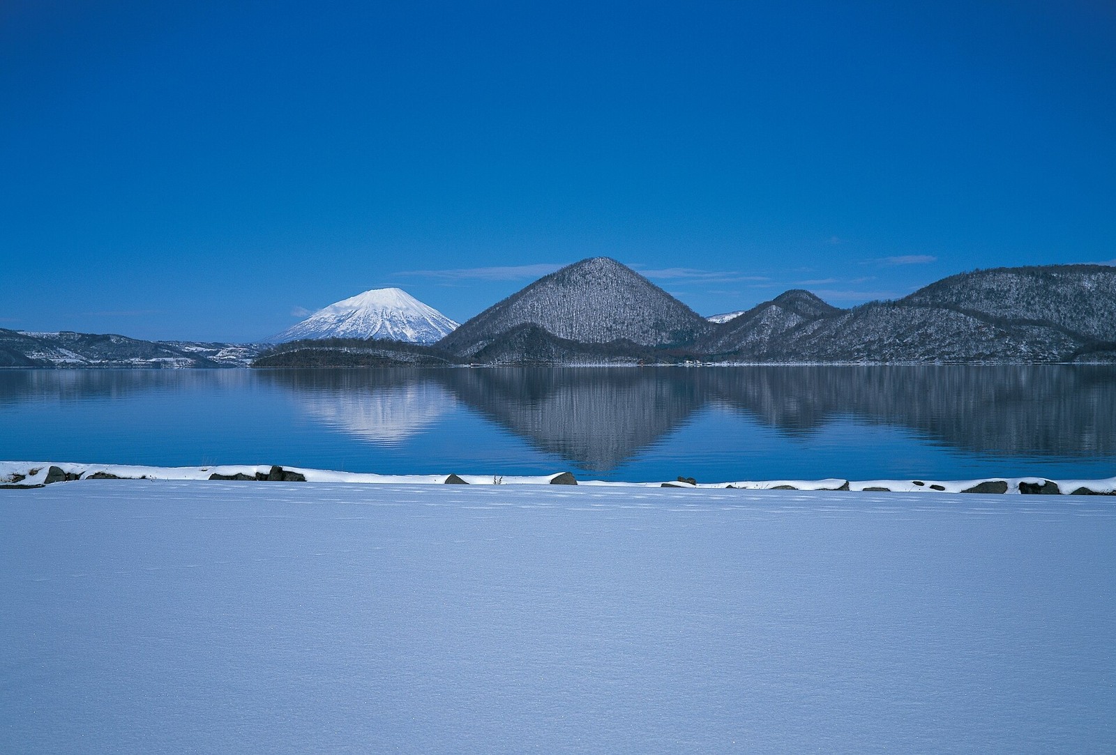 Snow beside Lake Toya and its central islands.