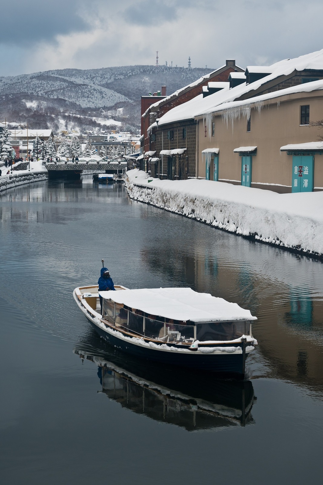 A canal boat beside snow-covered warehouses in February.