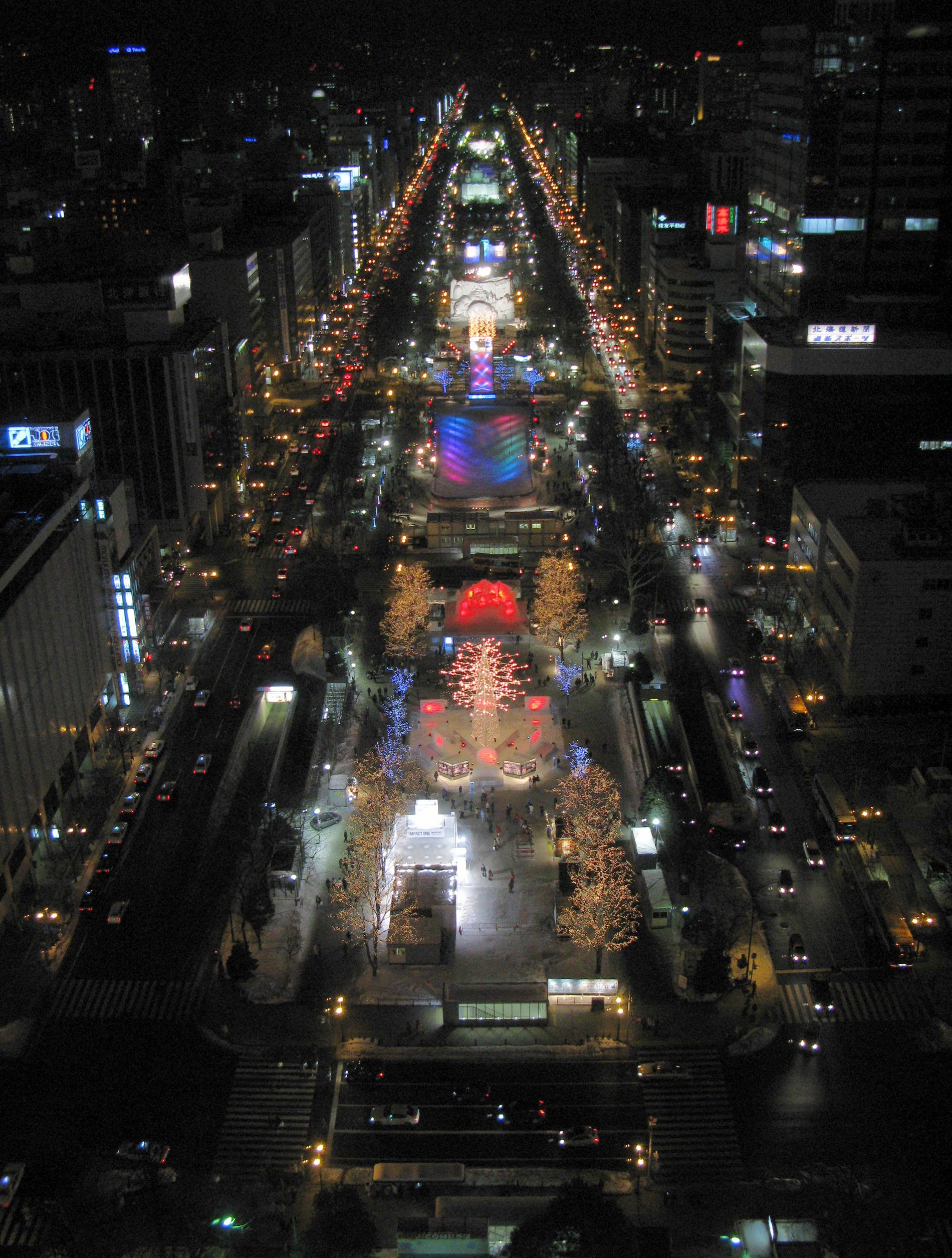 Odori Park seen from above during the 2010 Sapporo Snow Festival, with illuminated festival sites stretching into the distance.