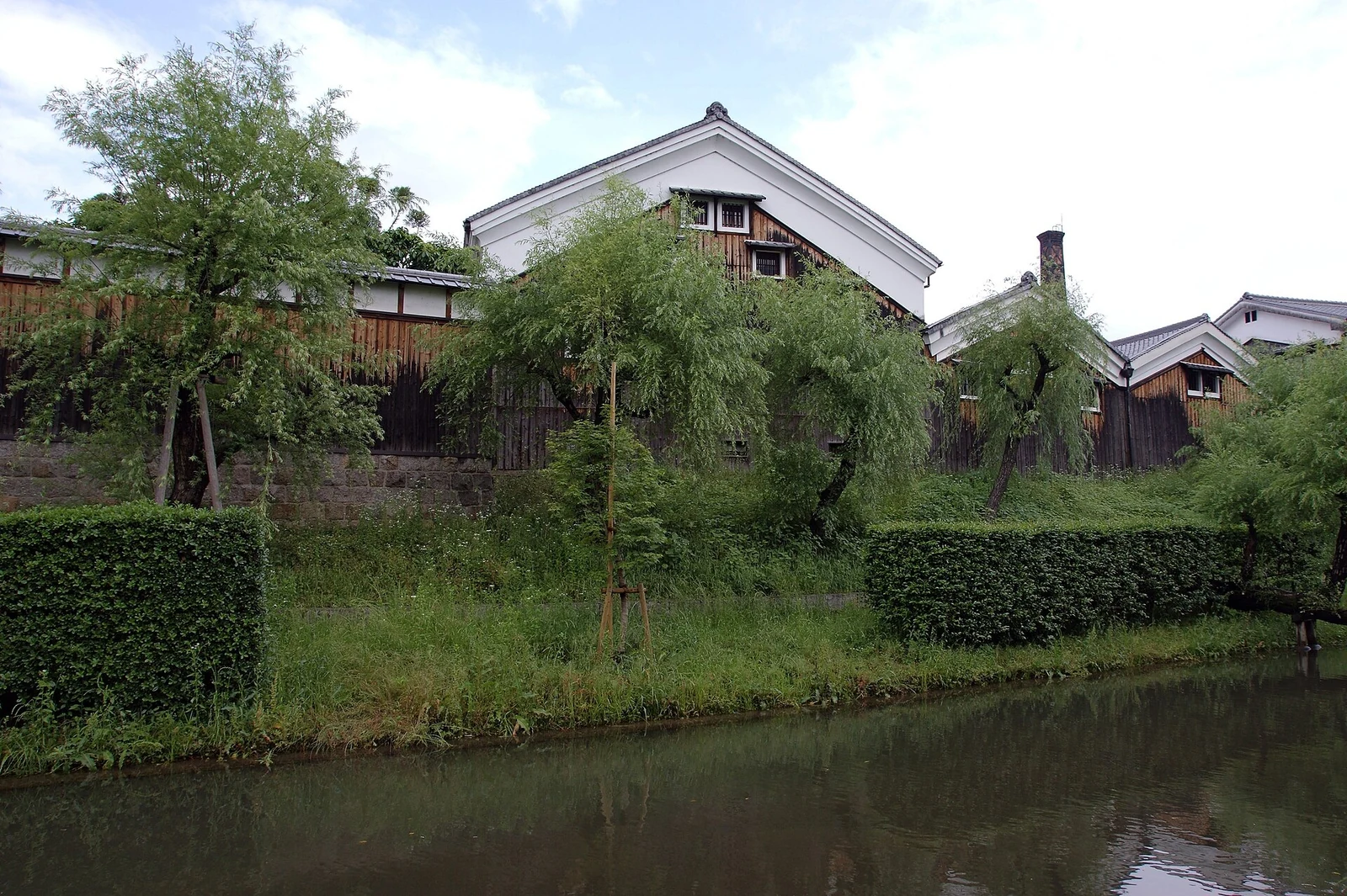 Warehouses beside the water and greenery.