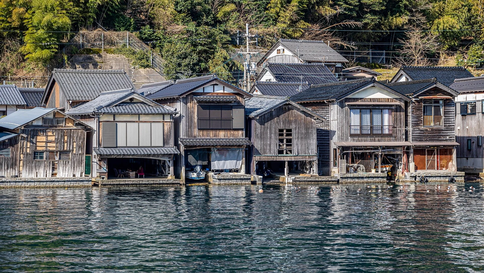 The boathouses seen closely from across the water.