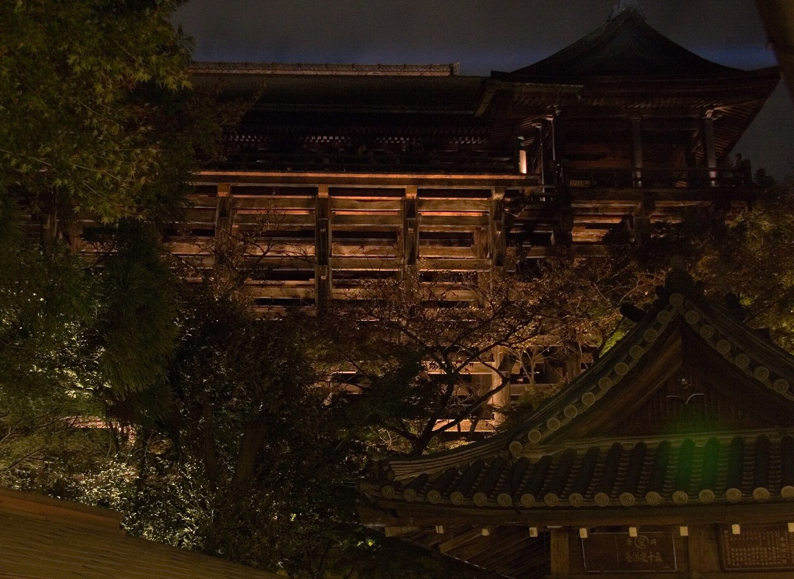 The wooden structure of Kiyomizu-dera during an autumn evening opening.