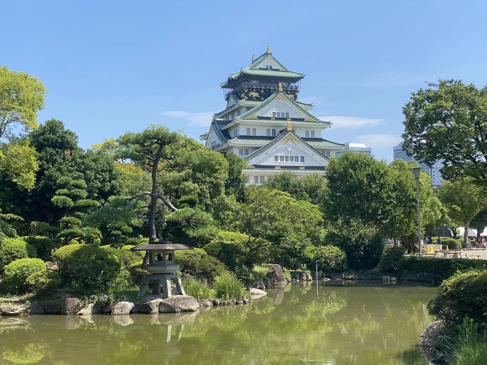 The main tower above the water and summer greenery.