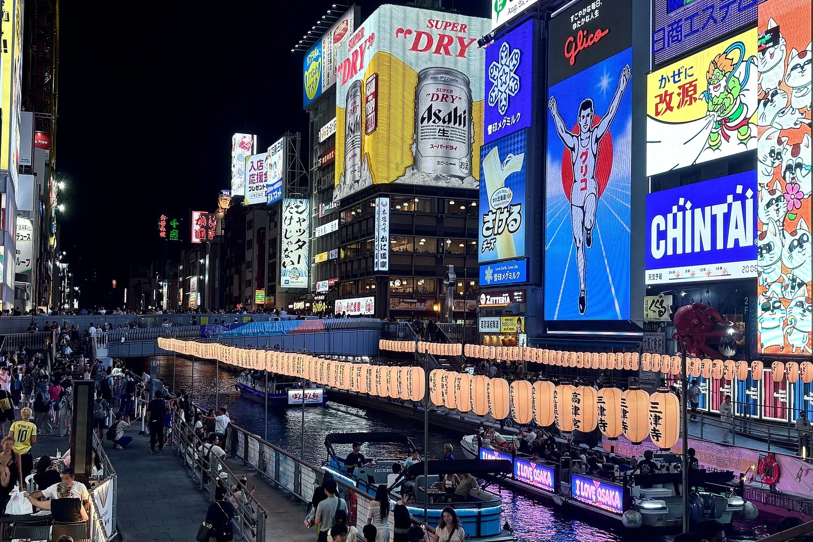 The canal-side signs illuminated on a summer night.