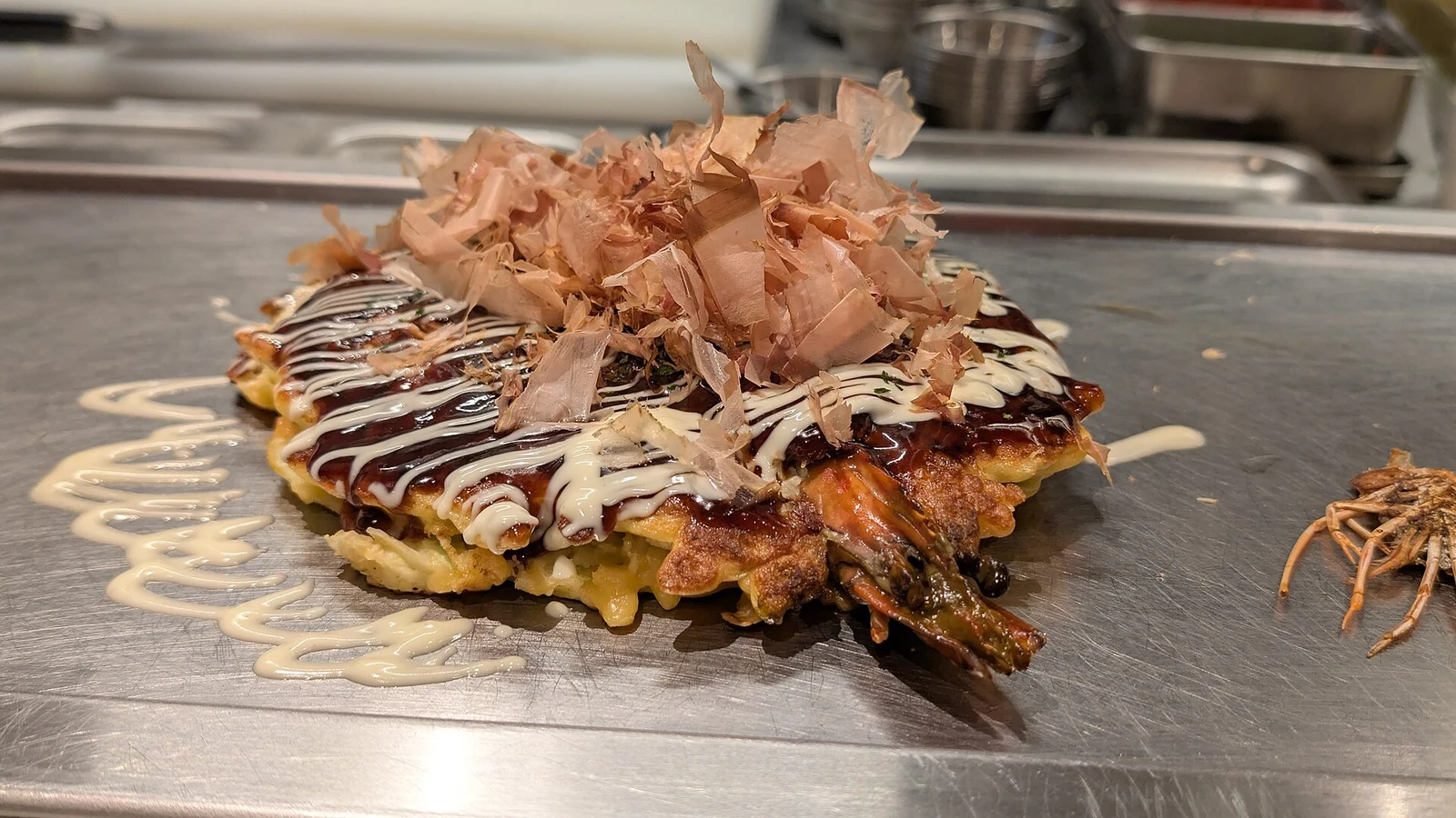 Bonito flakes and toppings on an Osaka okonomiyaki.