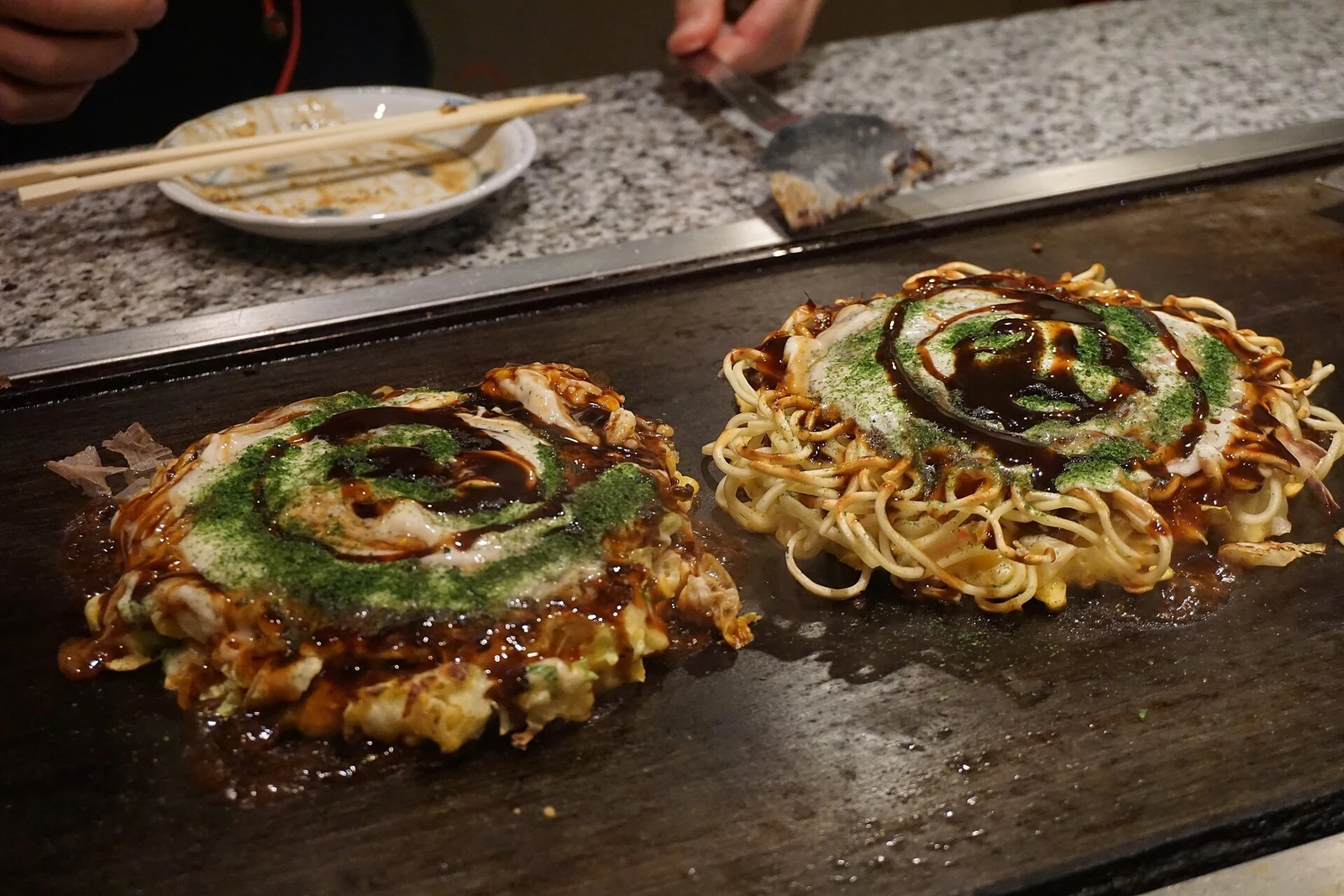 Okonomiyaki cooking on a teppan in Osaka.