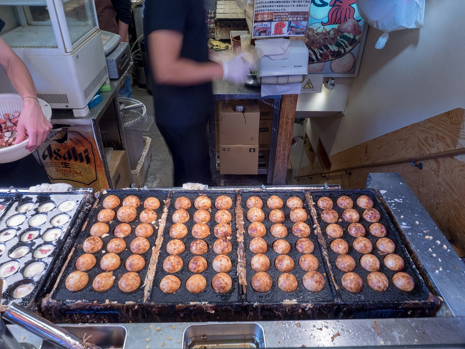 Takoyaki cooking in their round moulds.