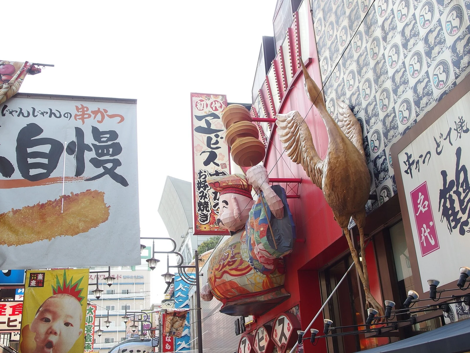 Large food signs above a Shinsekai street in 2014.