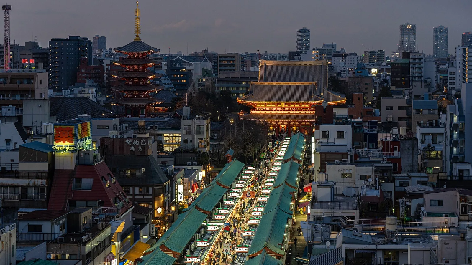 Nakamise shopping street leads toward the illuminated buildings of Senso-ji.