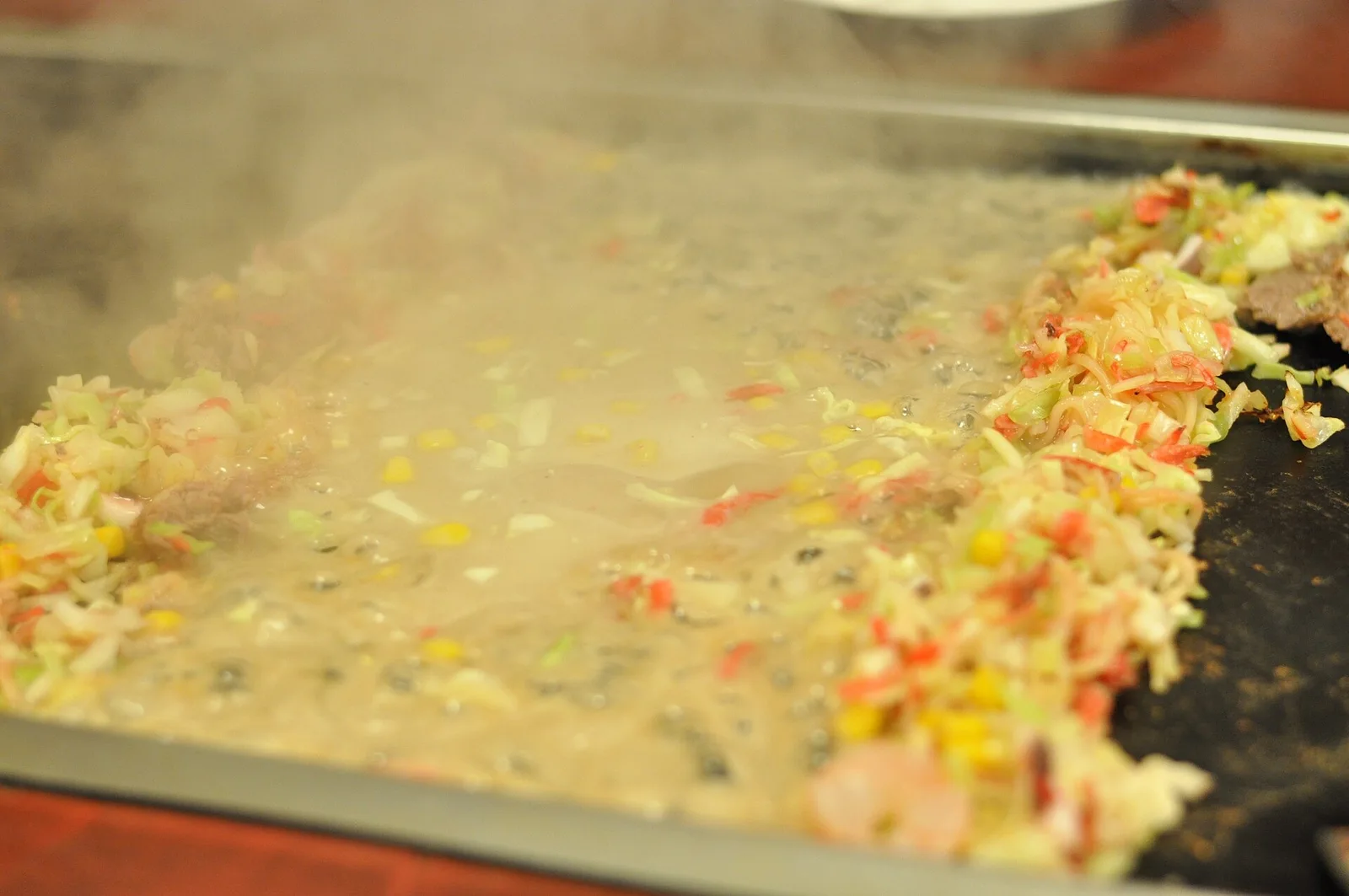Monjayaki batter cooking on a hot plate; a dish example photographed in March 2015.